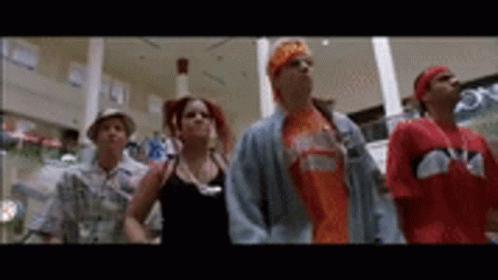 A Group Of People Are Standing Next To Each Other In A Shopping Mall . GIF