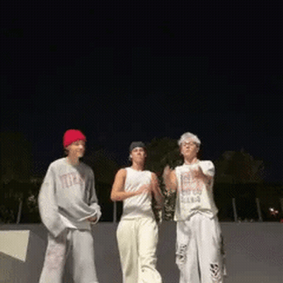 A Group Of People Are Standing Next To Each Other In A Skate Park At Night . GIF