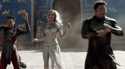 A Group Of People Are Standing Next To Each Other In Front Of A Building And Dancing . GIF