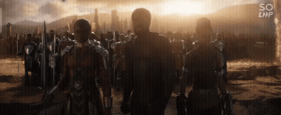 A Group Of People Are Standing Next To Each Other In Front Of A City . GIF