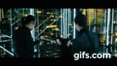 A Group Of People Are Standing Next To Each Other In Front Of A City Skyline At Night . GIF