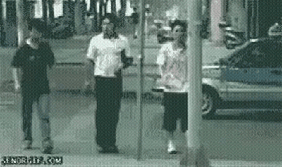 A Group Of People Are Standing Next To Each Other On A Sidewalk In Front Of A Car . GIF