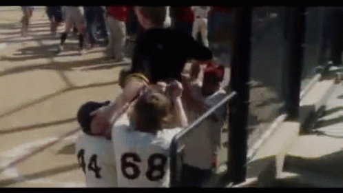 A Group Of People Are Standing On A Baseball Field And One Of Them Has The Number 68 On His Jersey . GIF