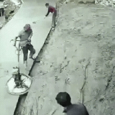 A Group Of People Are Standing On A Concrete Surface . GIF