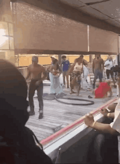 A Group Of People Are Standing On A Deck With A Hula Hoop GIF