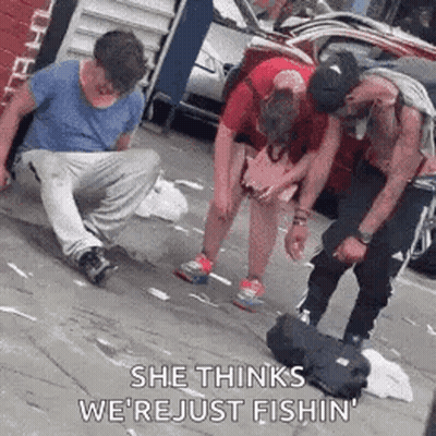 A Group Of People Are Standing On A Sidewalk And One Of Them Is Kneeling Down . GIF