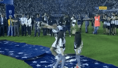 A Group Of People Are Standing On A Soccer Field With A Banner That Says Tico On It . GIF