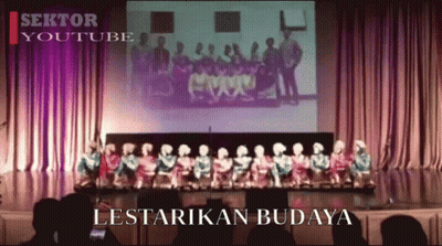 A Group Of People Are Standing On A Stage And The Words Lestarikan Budaya Are On The Screen GIF