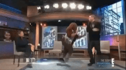 A Group Of People Are Standing On A Stage In Front Of A Sign That Says ' The Show ' On It . GIF