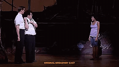A Group Of People Are Standing On A Stage Talking To Each Other In A Play . GIF