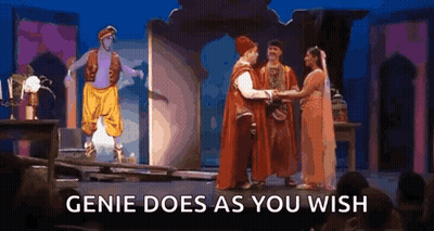 A Group Of People Are Standing On A Stage With The Words `` Genie Does As You Wish '' . GIF