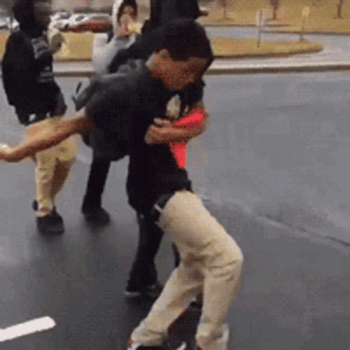 A Group Of People Are Standing On A Street . GIF
