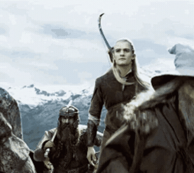 A Group Of People Are Standing On Top Of A Mountain With A Sword In Their Hand GIF