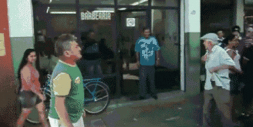A Group Of People Are Standing Outside Of A Barbearia GIF