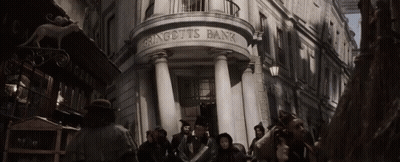 A Group Of People Are Standing Outside Of A Building That Says Gringotts Bank GIF