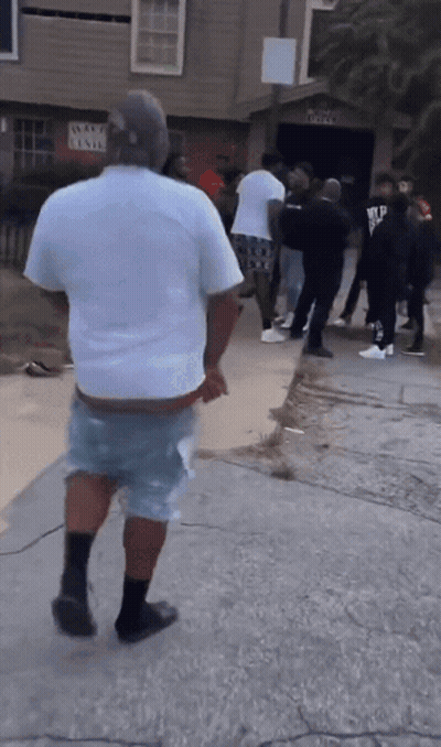 A Group Of People Are Standing Outside Of A Building With A Sign That Says " Wanted Level " GIF