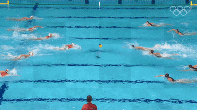 A Group Of People Are Swimming In A Pool With The Olympic Rings On The Wall GIF