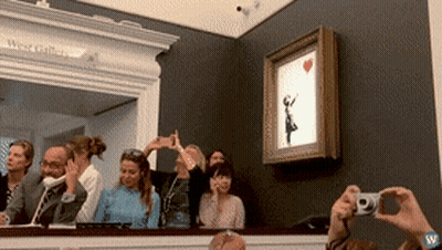 A Group Of People Are Taking Pictures Of A Painting Of A Girl With A Red Heart GIF