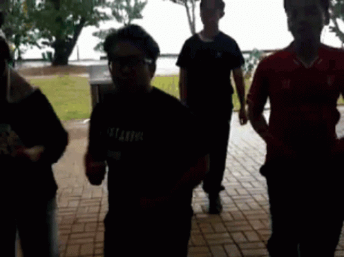 A Group Of People Are Walking Down A Brick Walkway And One Of Them Is Wearing A Shirt That Says Istanbul GIF