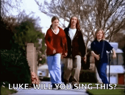 A Group Of People Are Walking Down A Sidewalk And One Of Them Is Asking Luke Will You Sing This . GIF