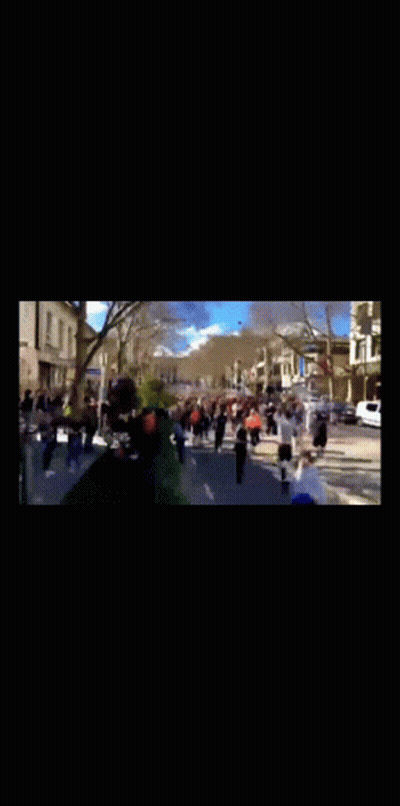 A Group Of People Are Walking Down A Street In A Blurry Photo GIF