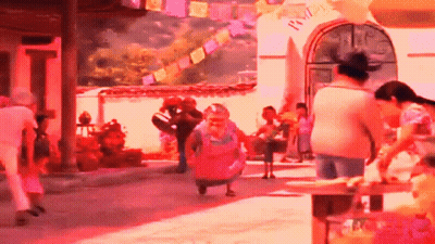 A Group Of People Are Walking Down A Street In Front Of A Building With A Sign That Says " Welcome " On It GIF