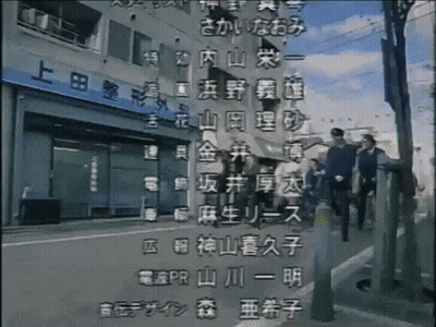 A Group Of People Are Walking Down A Street In Front Of A Building With Chinese Writing GIF