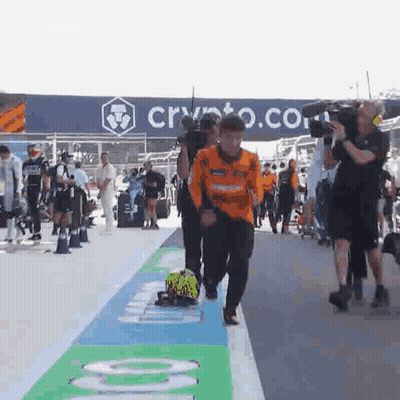 A Group Of People Are Walking Down A Street In Front Of A Sign That Says Crypto . GIF