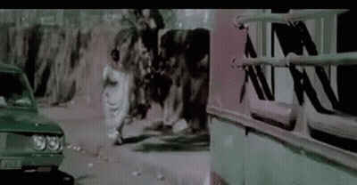 A Group Of People Are Walking Down A Street Next To A Car And A Bus . GIF