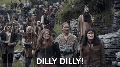 A Group Of People Are Walking In A Field With The Words Dilly Dilly Written On The Bottom . GIF