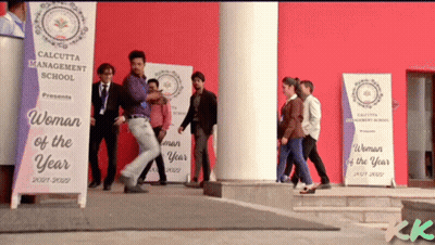 A Group Of People Are Walking In Front Of A Calcutta Management School Banner GIF