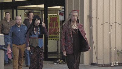 A Group Of People Are Walking In Front Of A Store With A Sign That Says Going Out Of Business GIF