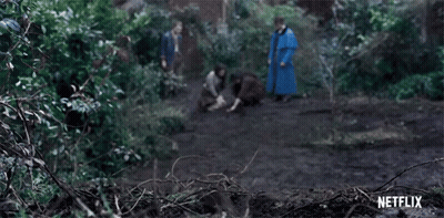 A Group Of People Are Walking Through A Forest With A Netflix Logo In The Background . GIF
