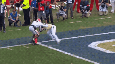 A Group Of People Are Watching A Football Game And One Of Them Is Wearing The Number 19 GIF