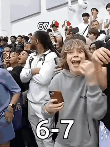 A Group Of People Are Watching A Game And One Of Them Is Wearing A Hoodie That Says Essentials On It GIF