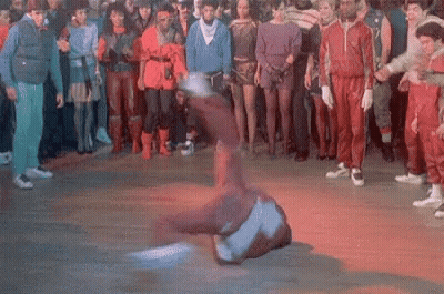 A Group Of People Are Watching A Man Do A Trick On A Dance Floor GIF