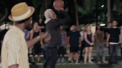 A Group Of People Are Watching A Man Throw A Basketball GIF