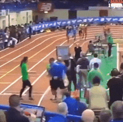 A Group Of People Are Watching A Track And Field Race GIF