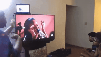 A Group Of People Are Watching A Video On A Flat Screen Television GIF