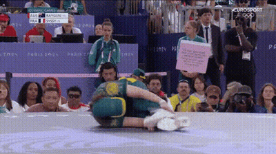 A Group Of People Are Watching A Wrestling Match With The Eurosport Logo In The Corner GIF