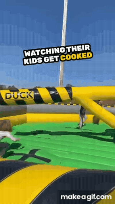 A Group Of People Are Watching Their Kids Get Cooked At An Inflatable Duck . GIF