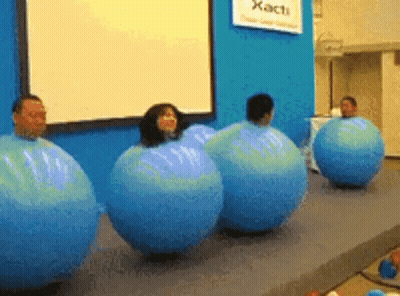 A Group Of People Are Wrapped In Blue Balloons In Front Of A Sign That Says Xact GIF