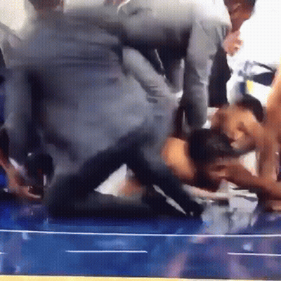 A Group Of People Are Wrestling On A Blue Wrestling Mat GIF