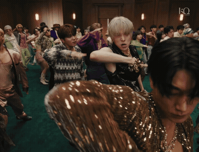 A Group Of People Dancing In A Room With The Letter Q On The Bottom Right GIF