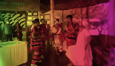 A Group Of People Dancing In Front Of A Sign That Says Royal Lodges GIF