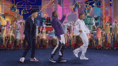 A Group Of People Dancing In Front Of A Sign That Says Spongebob Squarepants GIF