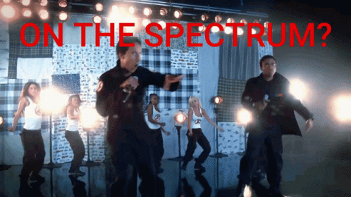 A Group Of People Dancing On A Stage With The Words On The Spectrum GIF