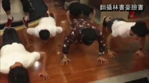 A Group Of People Doing Push Ups On The Floor With Chinese Writing On The Bottom GIF