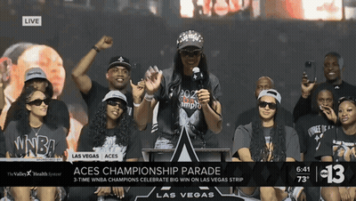 A Group Of People Gathered Around A Podium With The Words Aces Championship Parade On The Bottom GIF