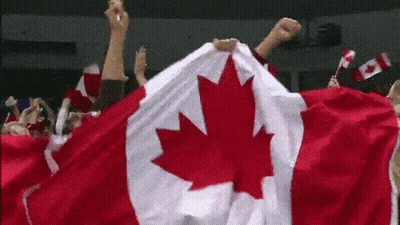 A Group Of People Holding A Canadian Flag In Their Hands GIF